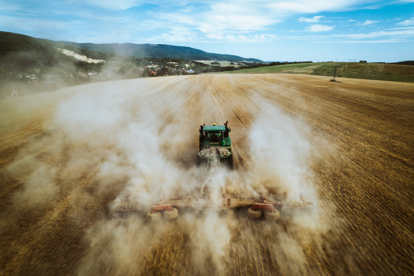 Aerial view of a tractor working on field. Agriculture and cultivation of industrial farms. Agribusiness.