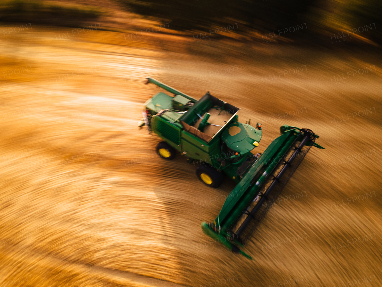 Aerial view of a harvester working on field. Agriculture and cultivation of industrial farms. Agribusiness.