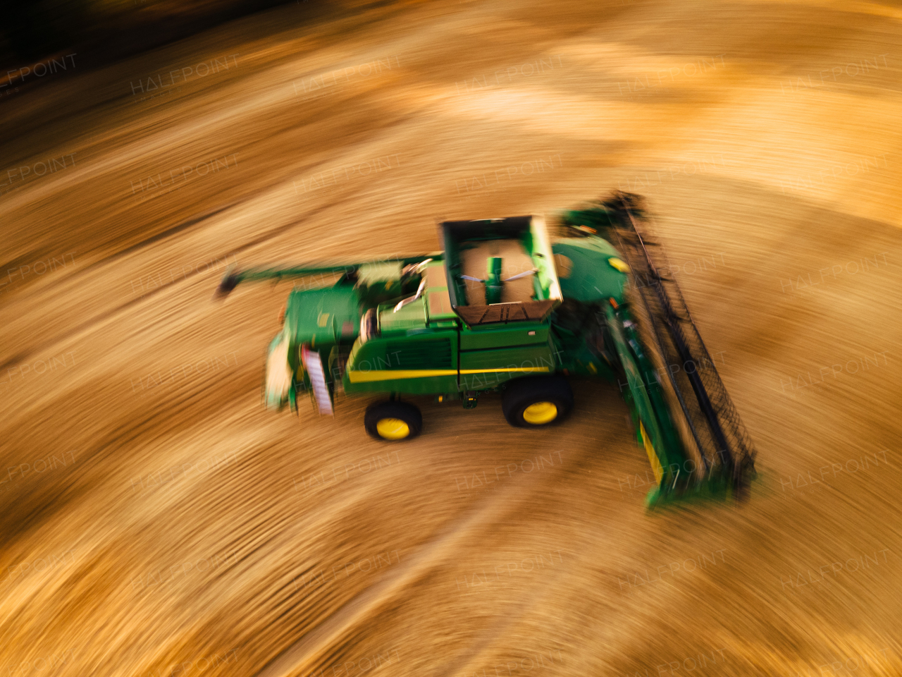 Aerial view of a harvester working on field. Agriculture and cultivation of industrial farms. Agribusiness.