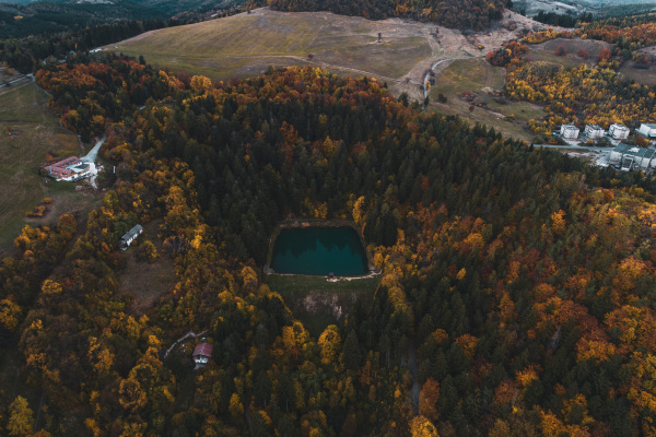 Top view of lake in the middle of beautiful autumn forest in Slovakia. Europe traveling concept.