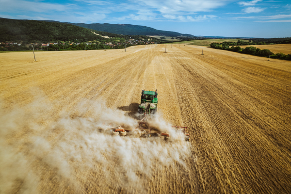 Aerial view of a harvester working on field. Agriculture and cultivation of industrial farms. Agribusiness.