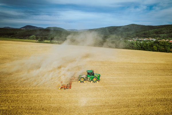 Aerial view of a harvester working on field. Agriculture and cultivation of industrial farms. Agribusiness.