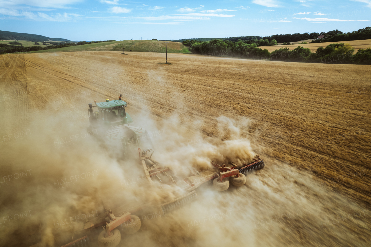 Aerial view of a tractor working on field. Agriculture and cultivation of industrial farms. Agribusiness.