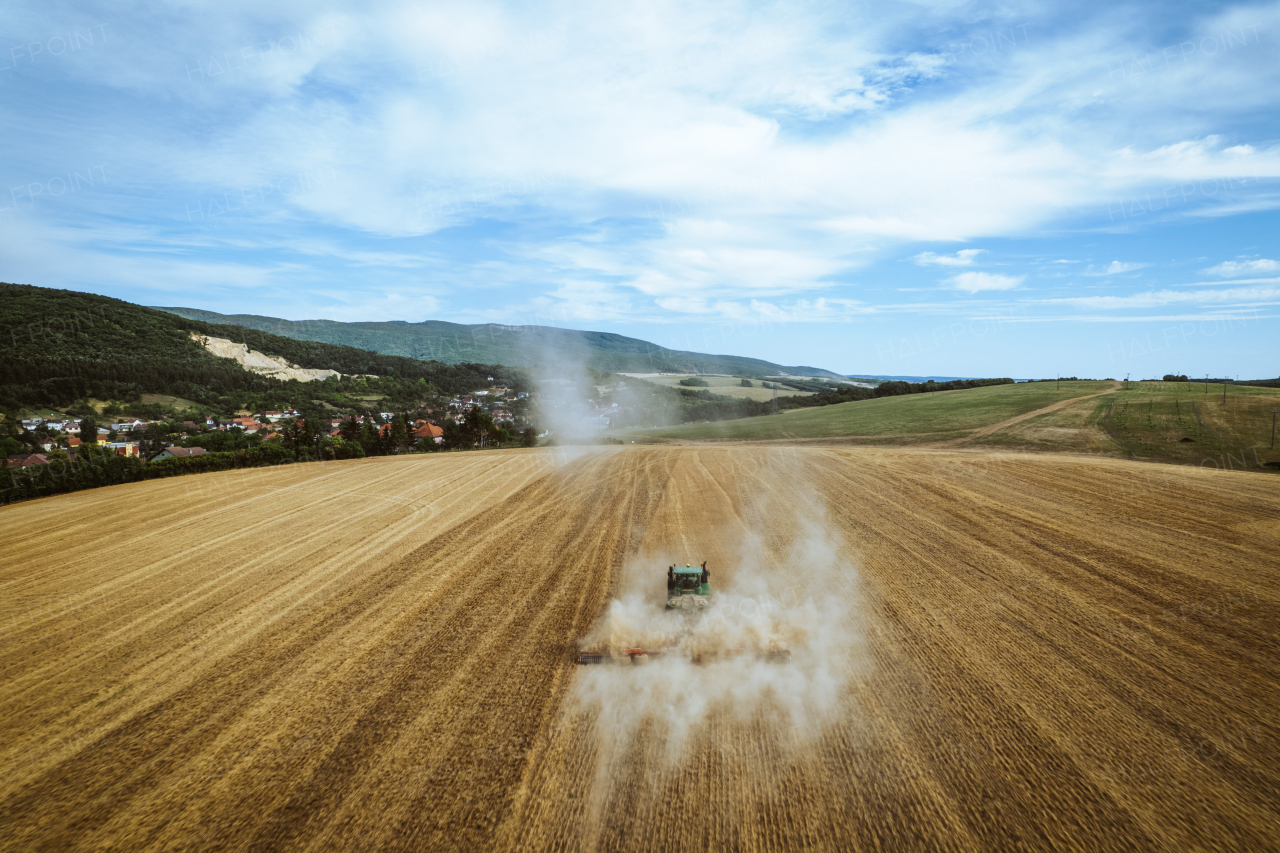 Aerial view of a harvester working on field. Agriculture and cultivation of industrial farms. Agribusiness.