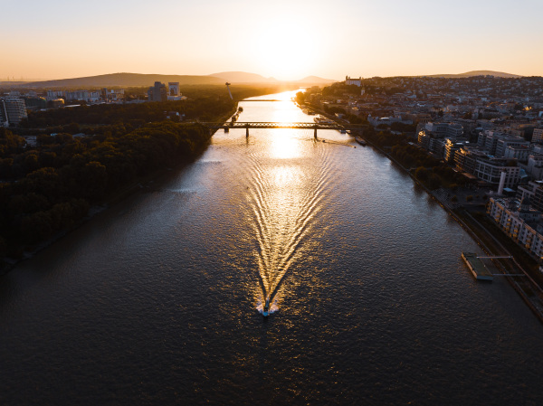 Aerial view of ship sailing on the Danube through Bratislava. The Danube river and passage under river bridges.