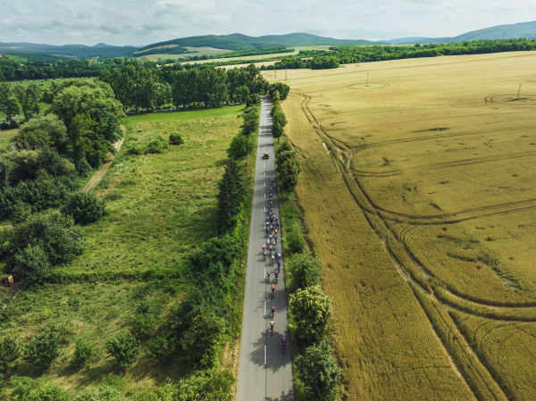 Top view of cycling races. Professional cyclists biking on the road during hot summer day.