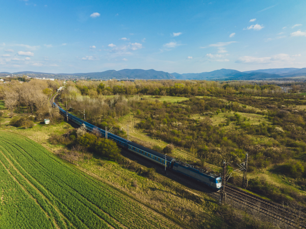 Aerial view of a yellow train in the middle of nature, field, during autumn sunny day.