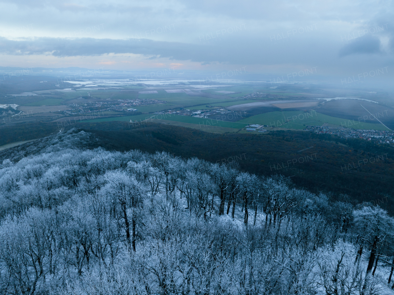 Aerial view of winter forest with frost or freeze line. Freezing on hills. Drone view of snowy landscape.