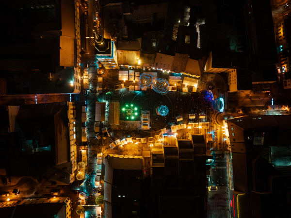 Aerial night shot of city during Christmas, winter and christmas decorations on city square. Chistmas market during holiday season in small city.