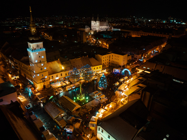 Aerial night shot of city during Christmas, winter and christmas decorations on city square. Chistmas market during holiday season in small city.