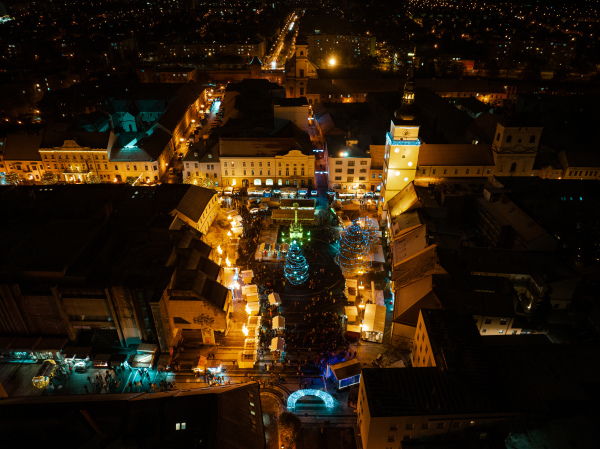 Aerial night shot of city during Christmas, winter and christmas decorations on city square. Chistmas market during holiday season in small city.