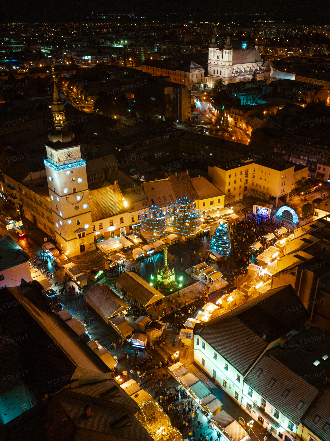 Aerial night shot of city during Christmas, winter and christmas decorations on city square. Chistmas market during holiday season in small city.