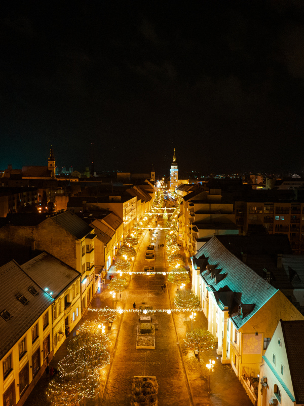 Aerial night shot of city during Christmas, winter and christmas decorations on city square. Chistmas market during holiday season in small city.