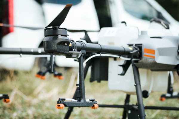 Close up of spray nozzles on agricultural drone. Dron spraying crops, distribute pesticides, herbicides and fertilizers efficiently and precisely. Technologies in modern farming.