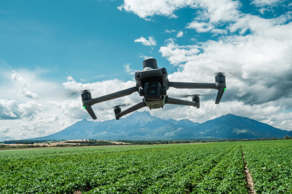 Aerial view of a drone moderning over green farm fields, monitoring, analyzing crop health. Agricultural drone in modern farming.