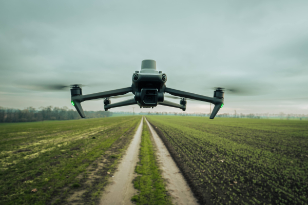 Aerial view of a drone moderning over green farm fields, monitoring, analyzing crop health. Agricultural drone in modern farming.