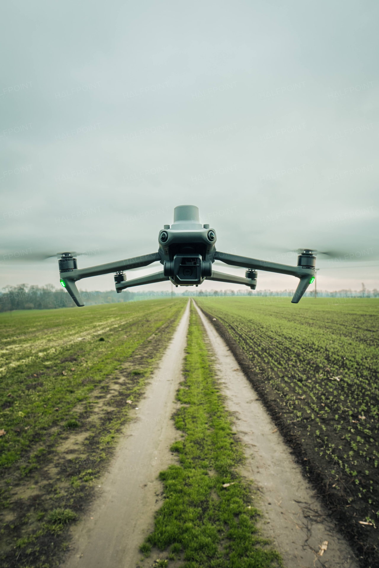 Aerial view of a drone moderning over green farm fields, monitoring, analyzing crop health. Agricultural drone in modern farming.