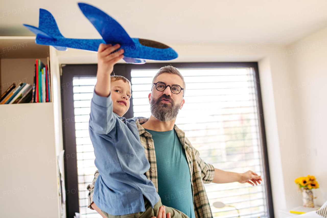 Playing with lightweight styrofoam planes. Playful father and son throwing, flying foam glider planes. Fathers day and parental love concept.