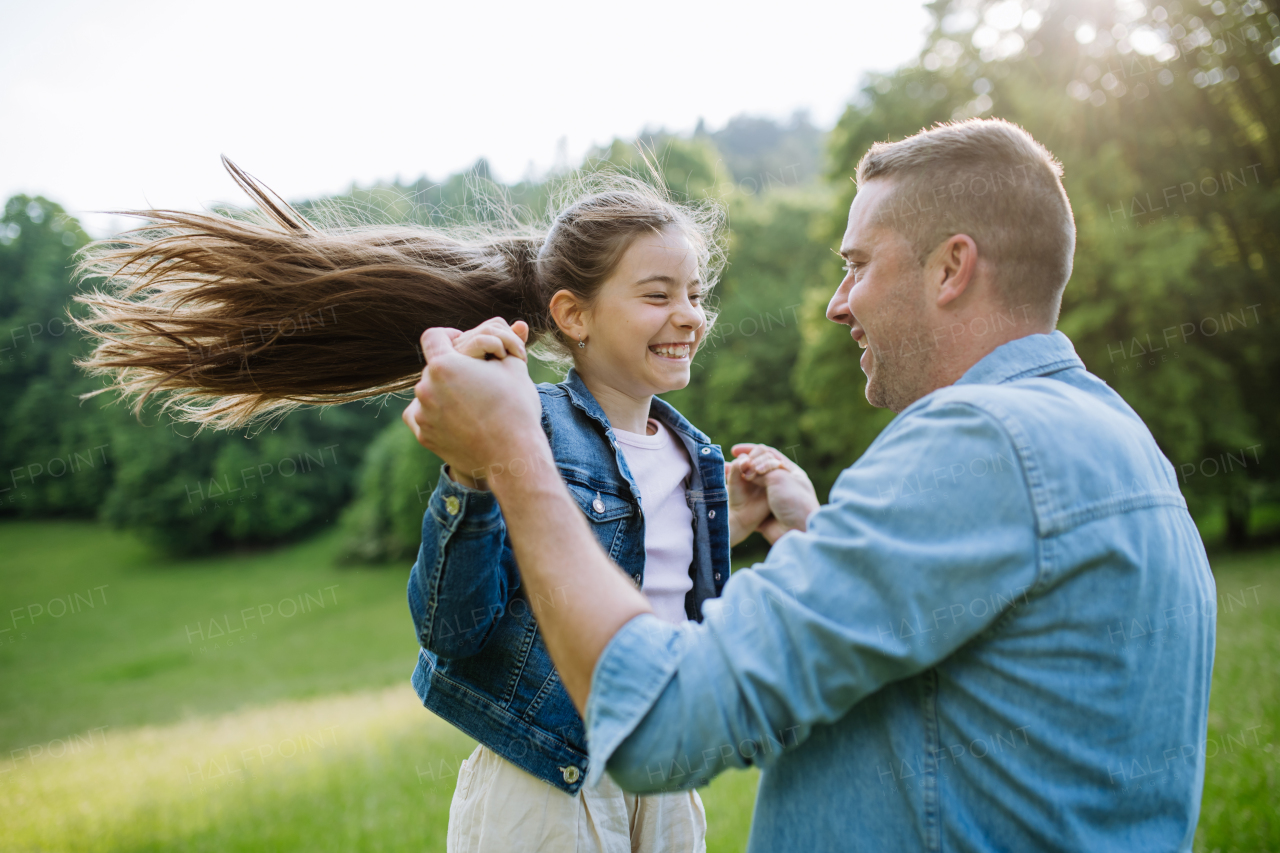 Father with daughter, playing at meadow, running, having fun. Concept of fathers's Day and fatherly love.