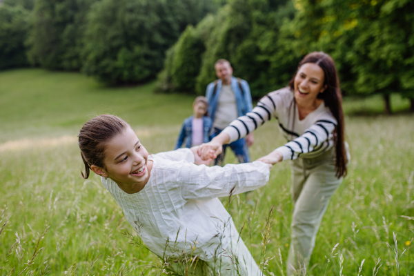 Beautiful mother with daughter, playing at meadow, running and having fun. Concept of Mother's Day and maternal love.