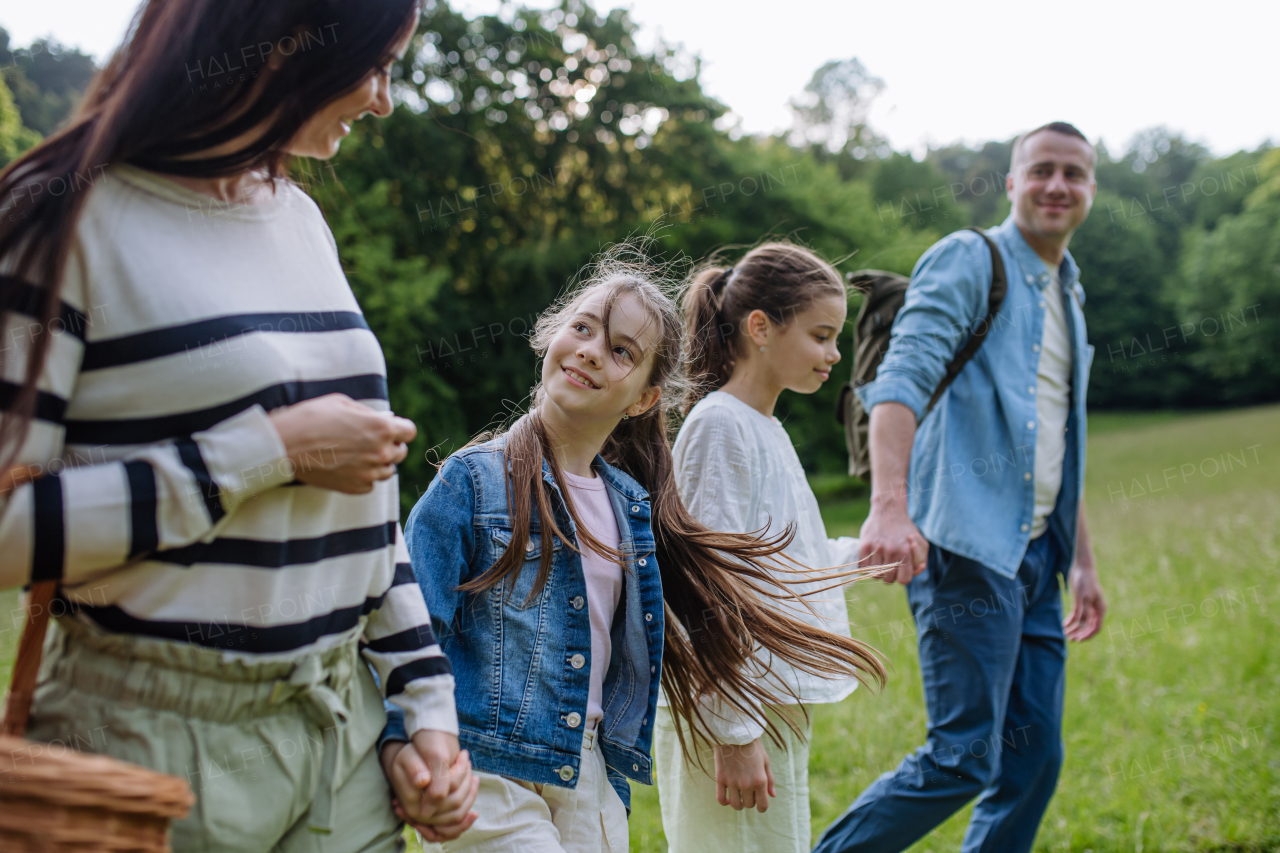 Family on walk in forest, going through meadow. Picking mushrooms, herbs and flowers picking in basket, foraging. Concept of family ecological hobby in nature.