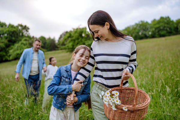 Family on walk in forest, going through meadow. Picking mushrooms, herbs and flowers picking in basket, foraging. Concept of family ecological hobby in nature.