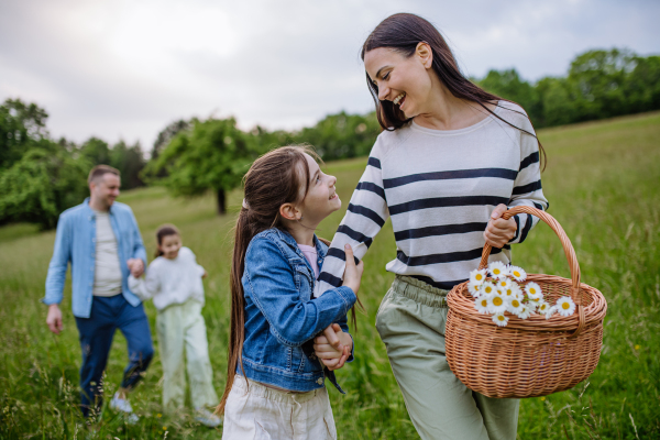 Family on interesting walk in forest, going through meadow. Successful mushroom, herbs medical plants or flowers picking, foraging. Concept of family ecological hobby in nature.