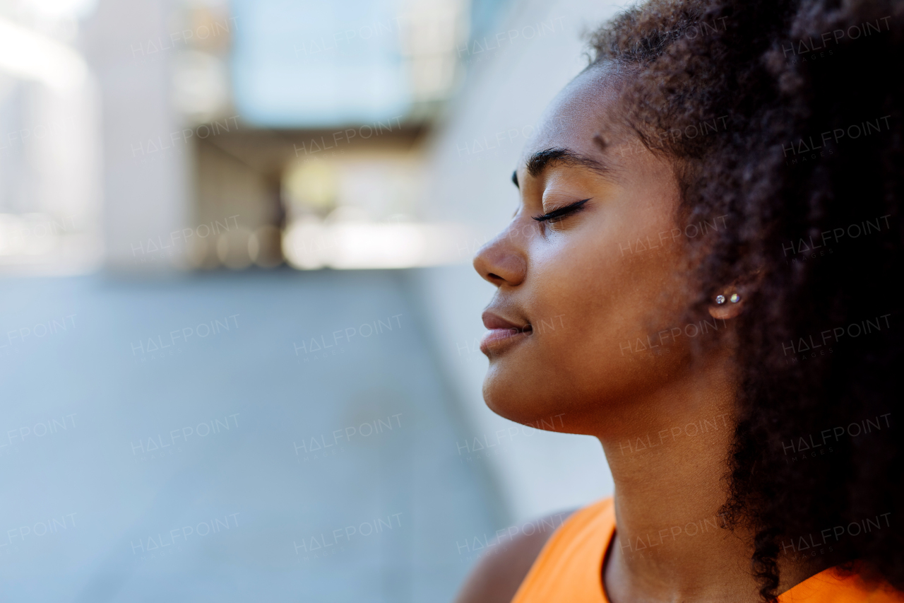 Multiracial girl resting during city walk, having closed eyes.