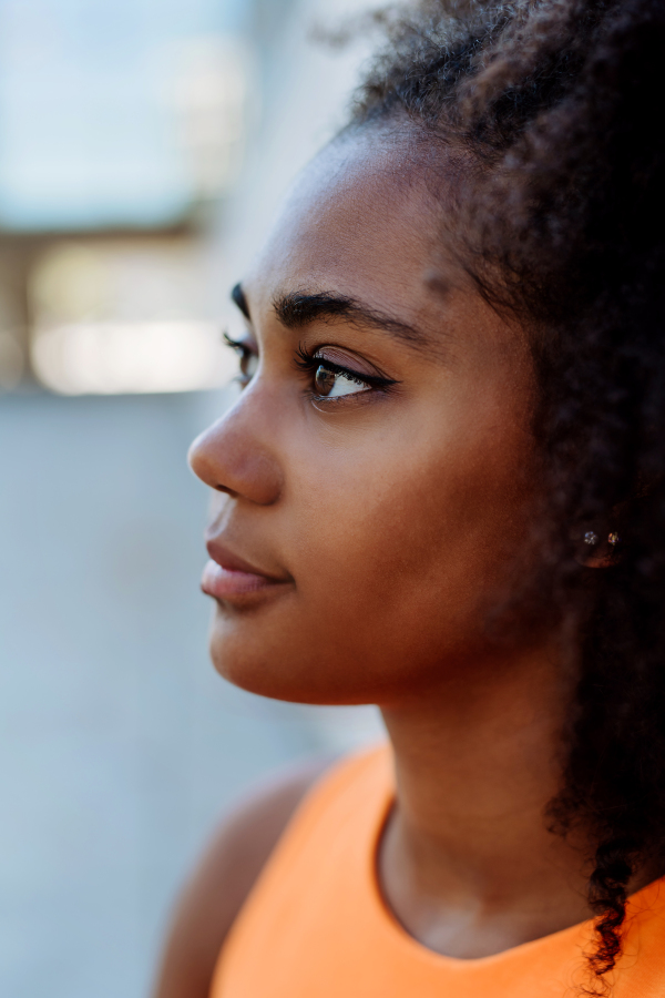 Portrait of multiracial girl in city,during hot summer day, side view.