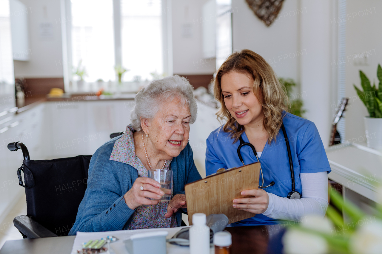 Nurse explaining how to dose medicines to a senior woman.