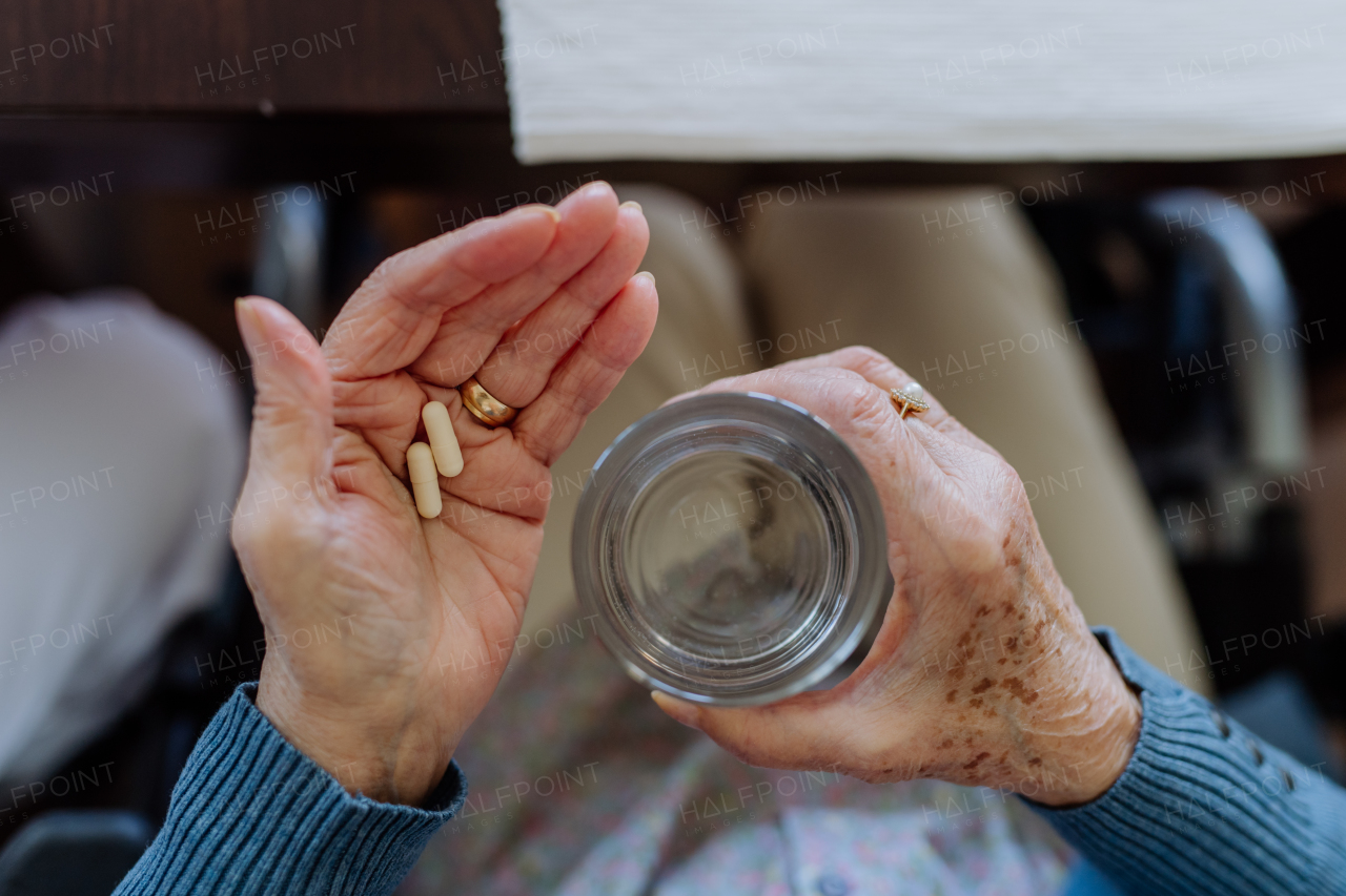 Top view of senior woman taking pills.