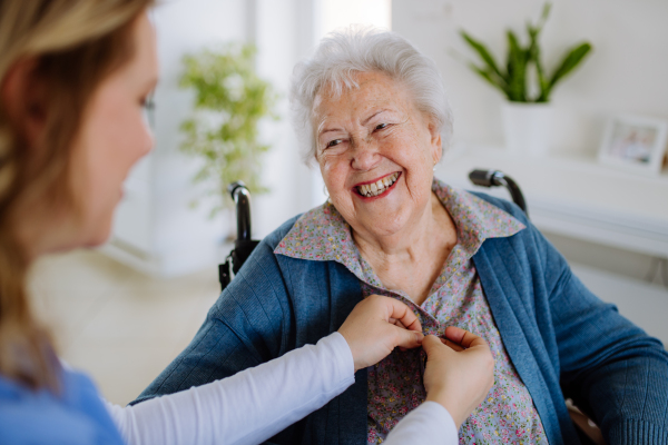 Young nurse taking care about senior woman client.