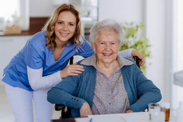 Portrait of nurse and her senior client on a wheelchair.