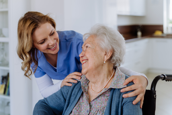 Portrait of nurse and her senior client on a wheelchair.