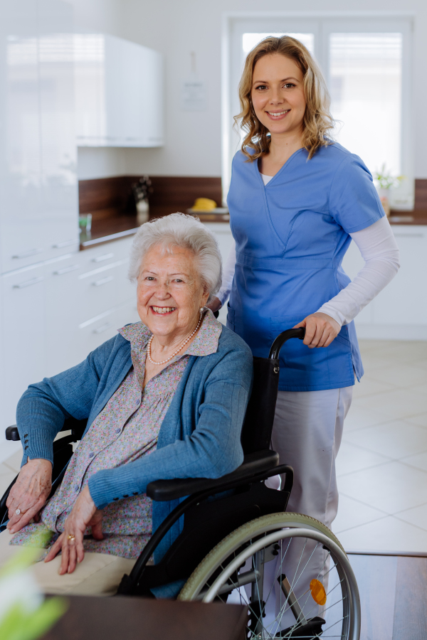 Portrait of nurse and her senior client on a wheelchair.