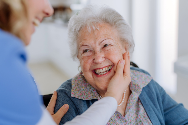 Close up of a nurse stroking cheek of senior woman.