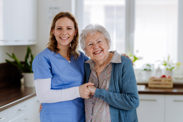 Nurse hugging her senior woman client.