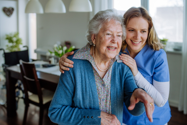 Nurse hugging her senior woman client.