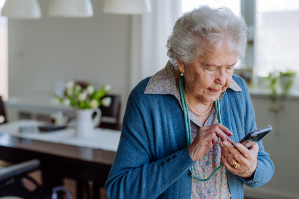 Portrait of smiling senior woman with smartphone.