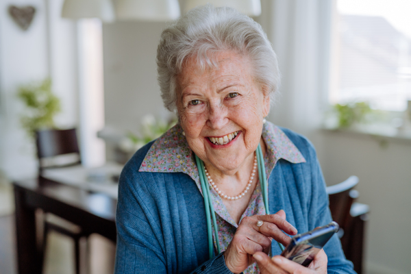 Portrait of smiling senior woman with smartphone.