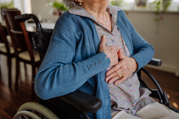 Close up of senior woman on wheelchair having pain in her chest.