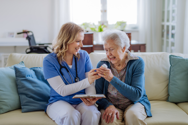 Nurse explaining how to dose medicines to a senior woman.