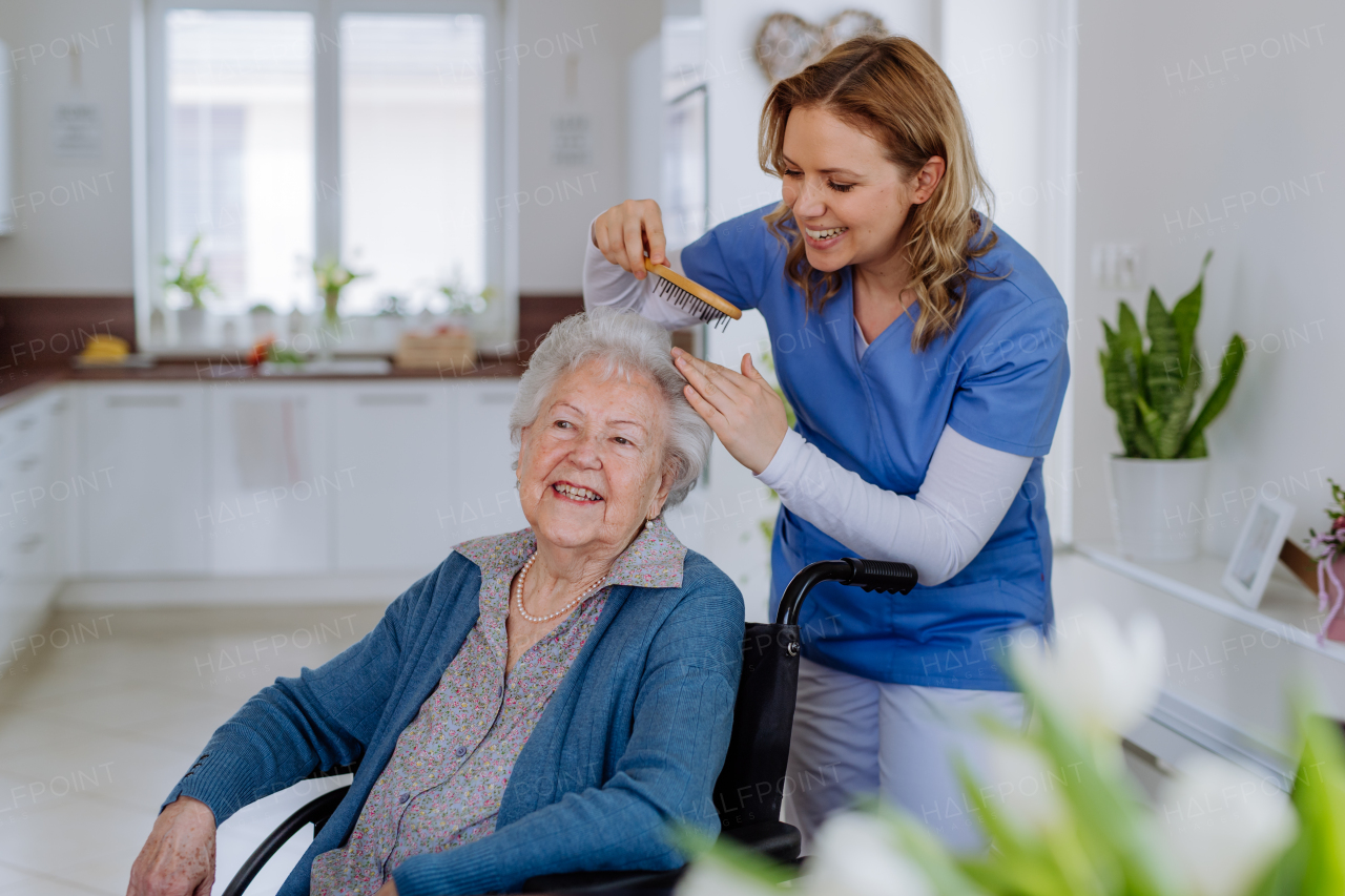 Young nurse doing hairstyle to her senior woman client.