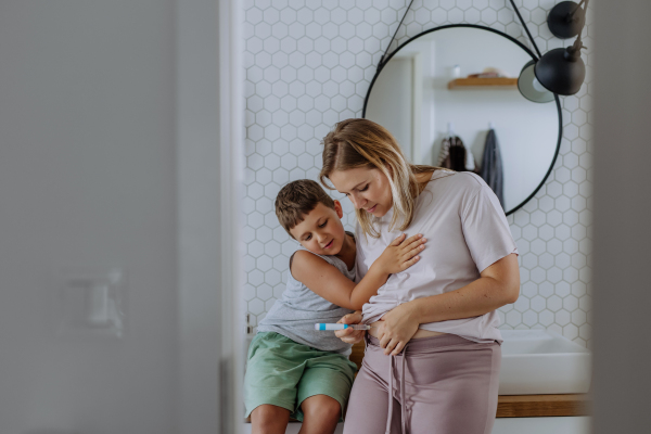 Woman injecting insulin in her belly, while her son watching and supporting her. Close up of mother with with type 1 diabetes taking insuling with syringe needle.