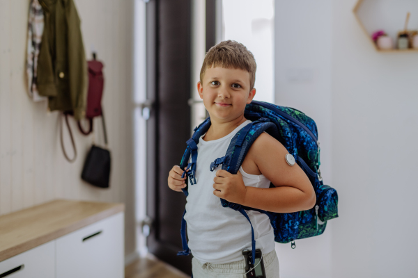 Diabetic boy with a continuous glucose monitor going to school. Special educational needs of diabetic children. CGM device making life of school boy easier, helping manage his illness and focus on other activities.