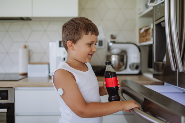 Diabetic boy with a continuous glucose monitor can't drink sweetened soda, sugar drink.