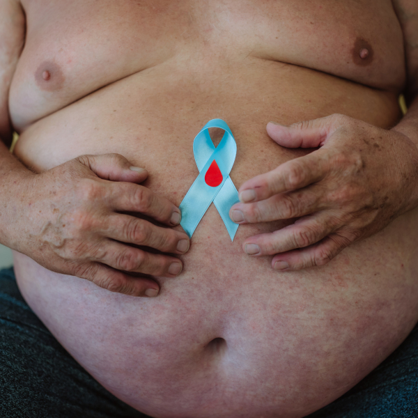 Overweight man holding a blue diabetes support ribbon as a symbol of diabetes awareness. November as Diabetes Awareness Month. 14 November as World Diabetes Day.