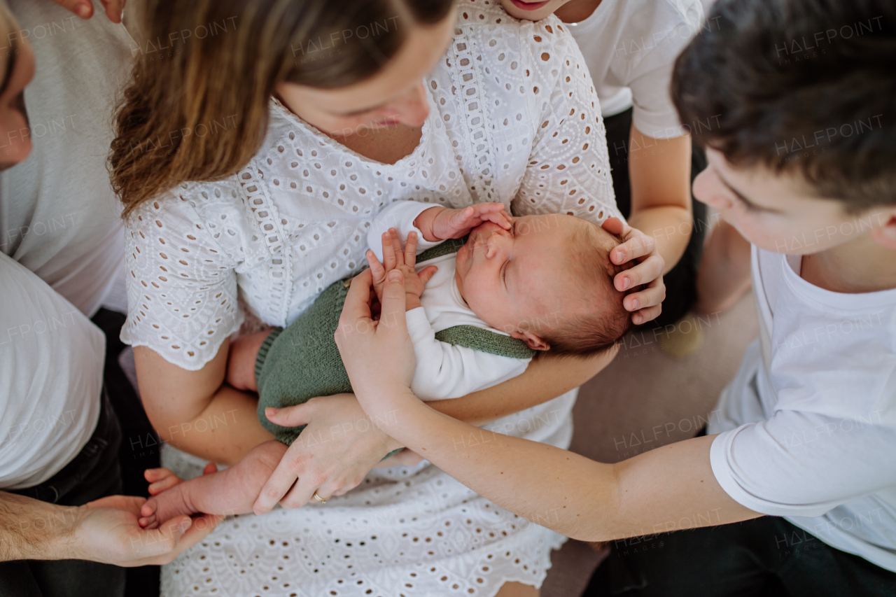 Big family with four sons enjoying their newborn baby.