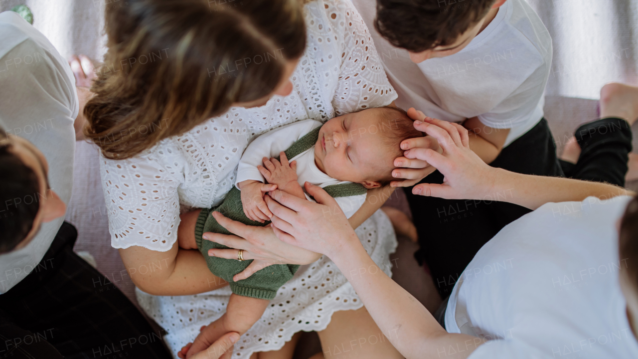 Big family with four sons enjoying their newborn baby.