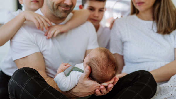 Big family with four sons enjoying their newborn baby.